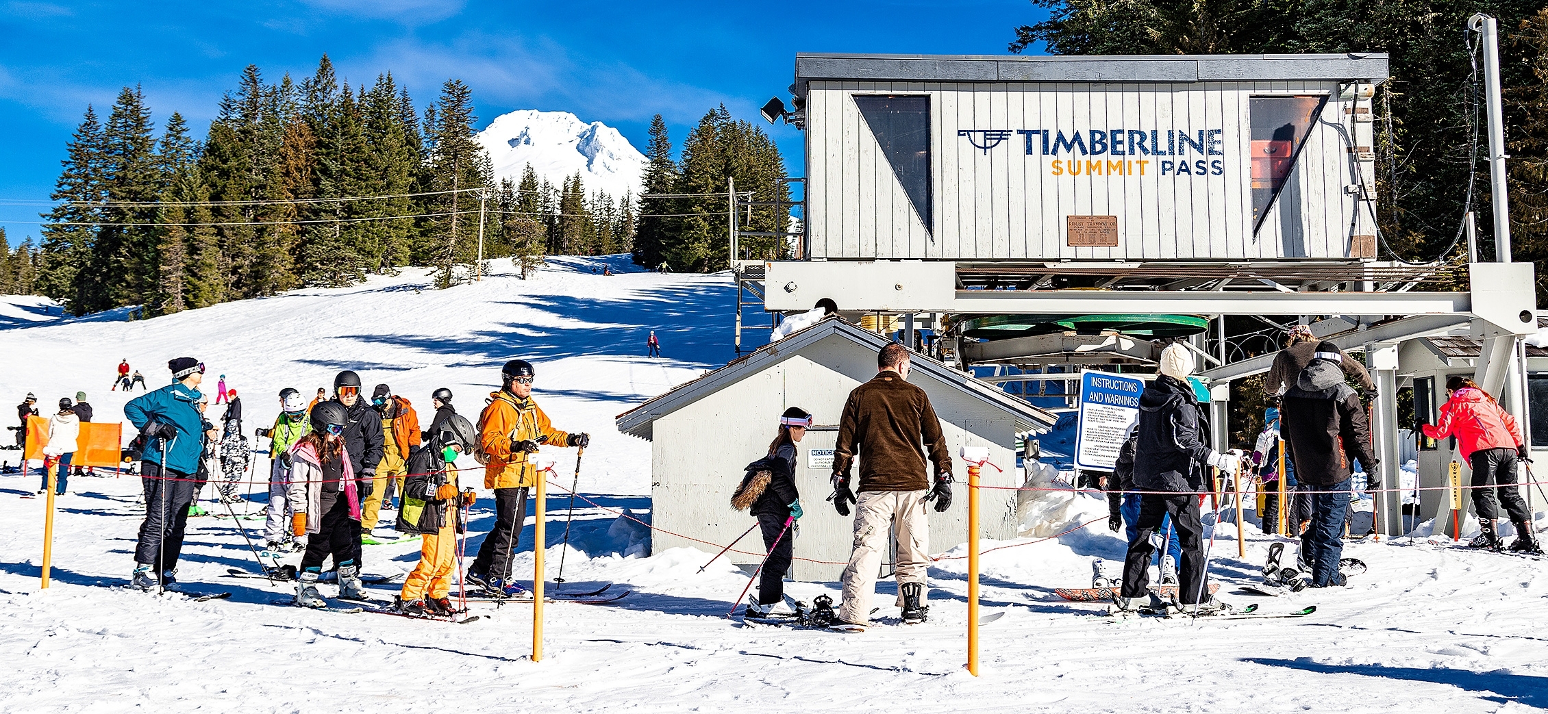 SKIERS AND SNOWBOARDERS IN LINE AT THE TIMBERLINE SUMMIT PASS CHAIRLIFT ON MT. HOOD