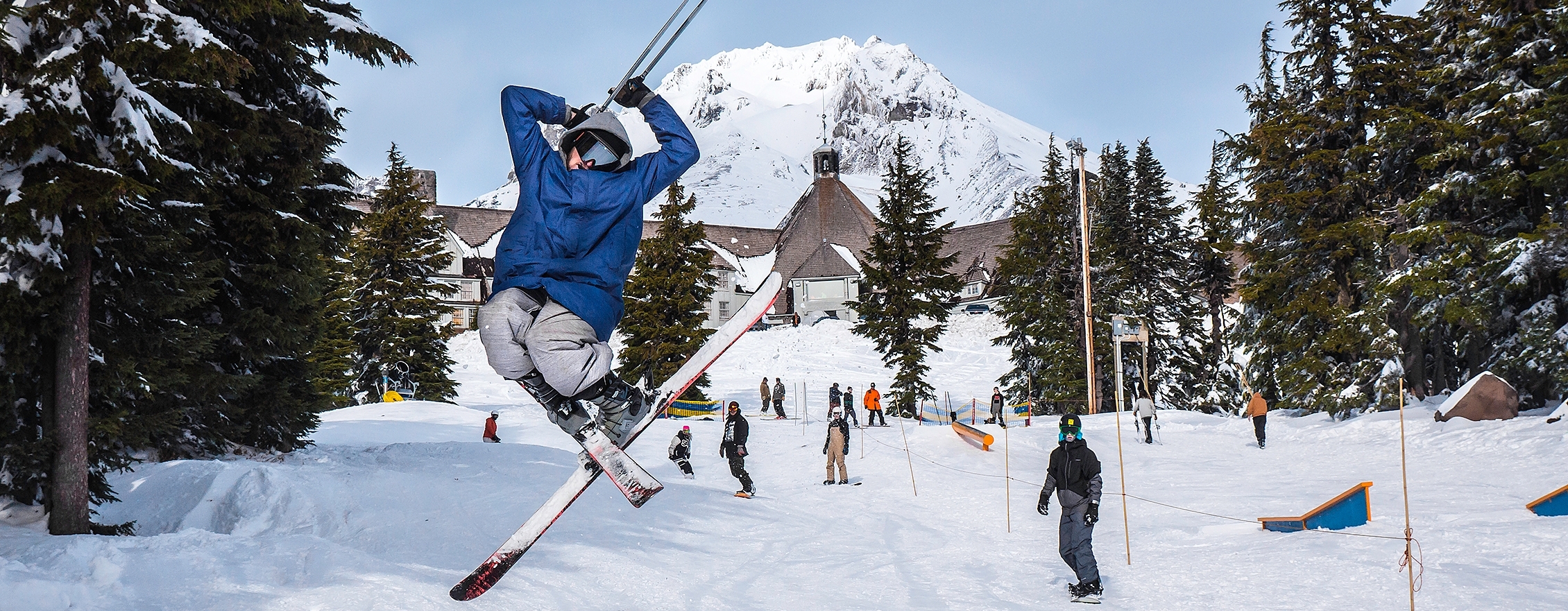 SKIERS AND SNOWBOARDERS IN FRONT OF TIMBERLINE LODGE AND MT. HOOD