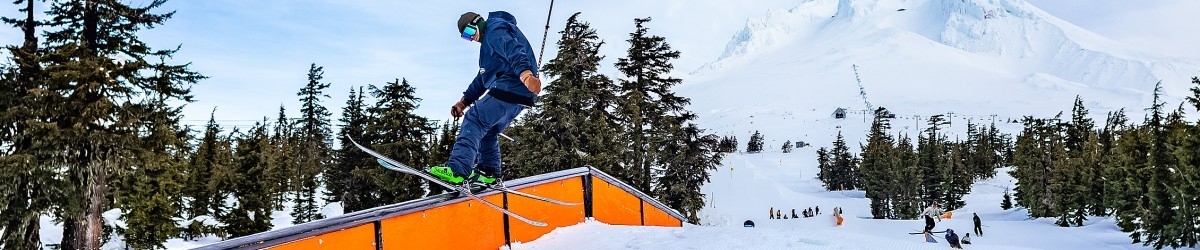 SKIER RIDING A RAIL IN A TIMBERLINE TERRAIN PARK ON MT. HOOD