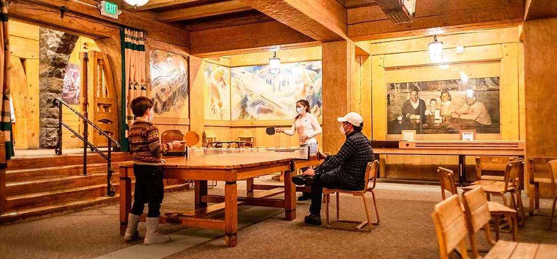 KIDS PLAYING PING PONG IN THE BARLOW ROOM WITH A PARENT WATCHING