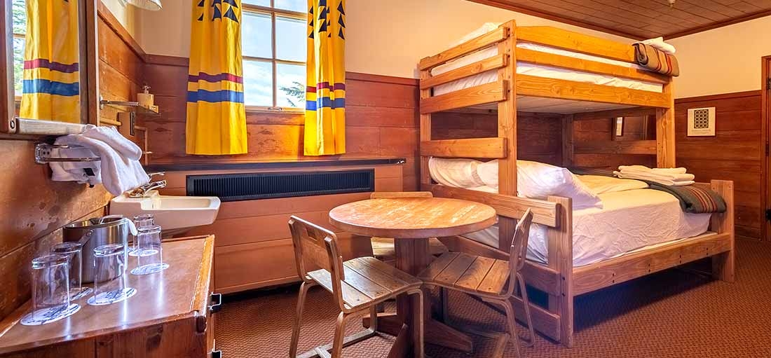 MEDIUM TIMBERLINE CHALET HOTEL ROOM WITH THREE BUNK BEDS, AND SEATING AREA