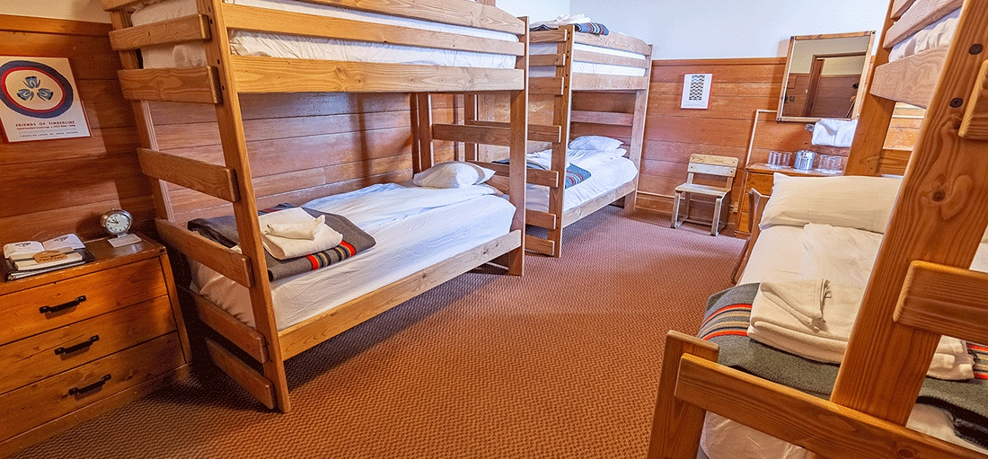 MEDIUM TIMBERLINE CHALET HOTEL ROOM WITH THREE BUNK BEDS, AND SEATING AREA