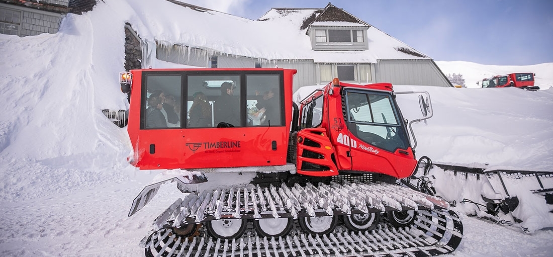 RED TIMBERLINE SNOWCAT TRANSPORTING GUESTS IN THE SNOW