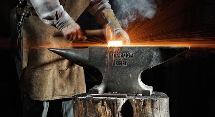 Blacksmith Darryl Nelson pounding iron on an anvil