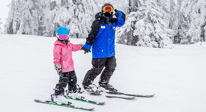 TIMBERLINE SKI SCHOOL INSTRUCTOR AND CHILD ON SKIS