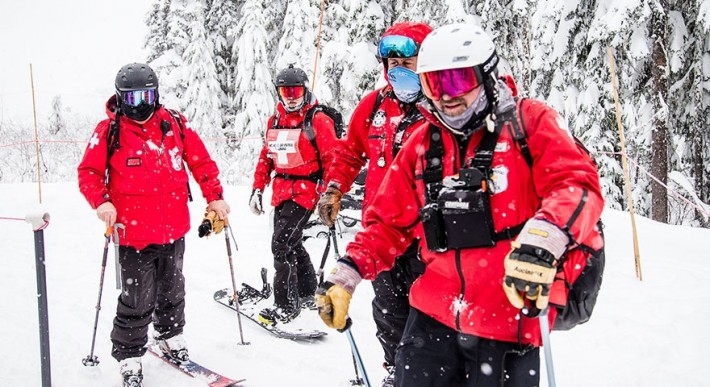 FOUR MT. HOOD SKI PATROLLERS IN RED COATS AT TIMBERLINE