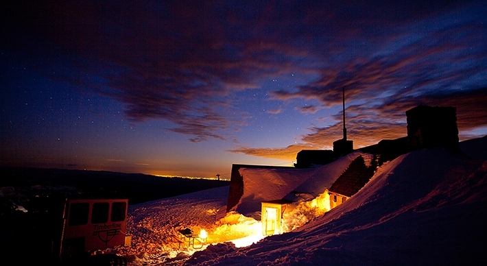 SNOWY SILCOX HUT AT NIGHT BENEATH A MOODY SKY