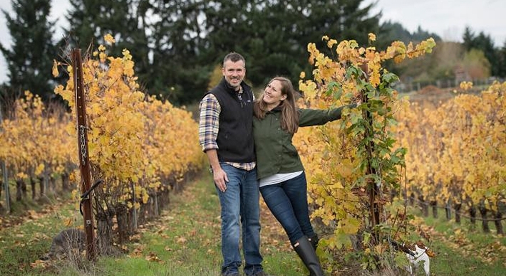 KEN PAHLOW AND ERICA LANDON OF WALTER SCOTT WINES POSING IN A VINEYARD IN THE FALL