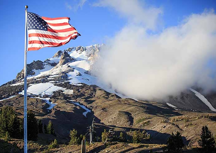 U.S. FLAG FLYING IN FRONT OF MT. HOOD AT TIMBERLINE