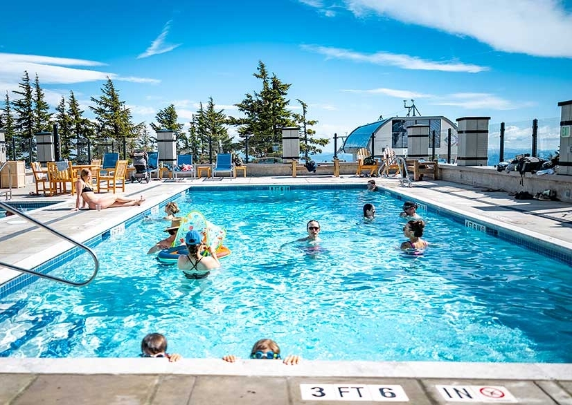 Folks enjoying Timberline's heated outdoor pool in the sunshine