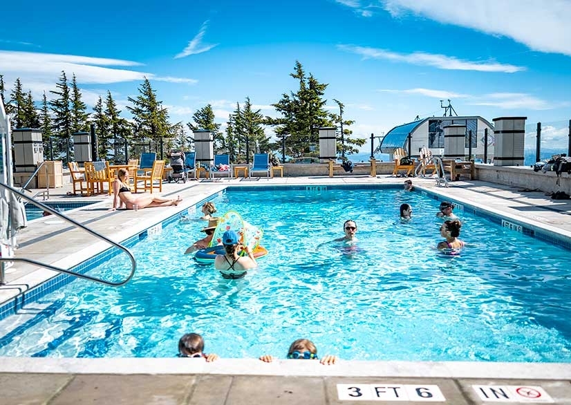 Folks enjoying Timberline's heated outdoor pool and a sunny day