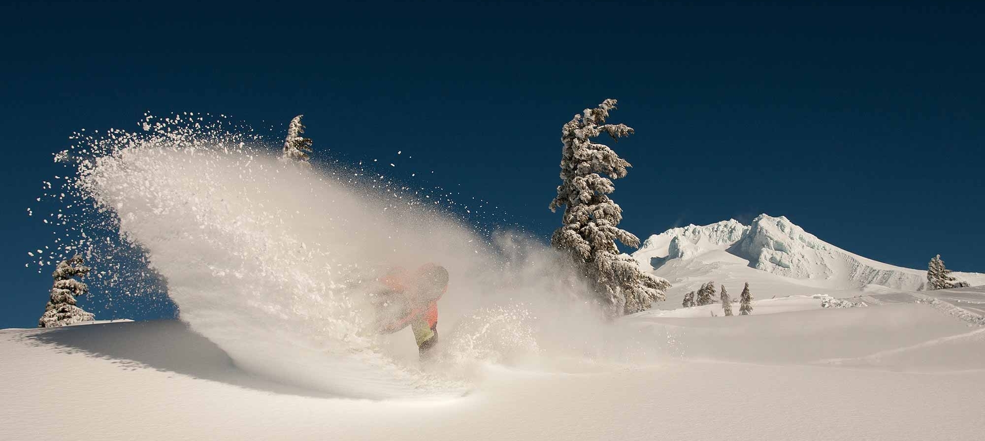 TIMBERLINE SKI AND SNOWBOARD SWOOSH IN THE SNOW WITH MT. HOOD IN THE BACKGROUND