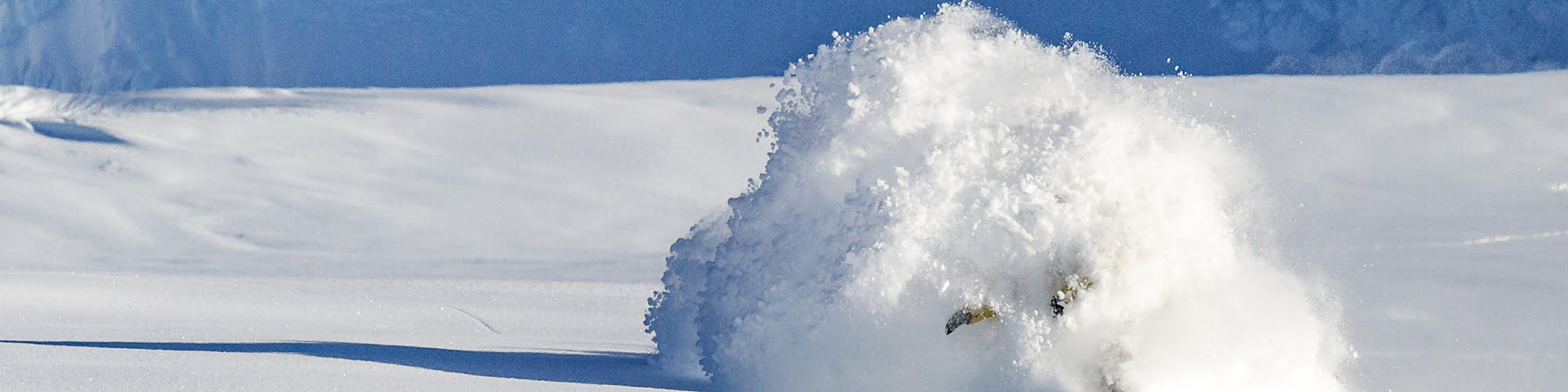 Snow boarder boarding through the snow.