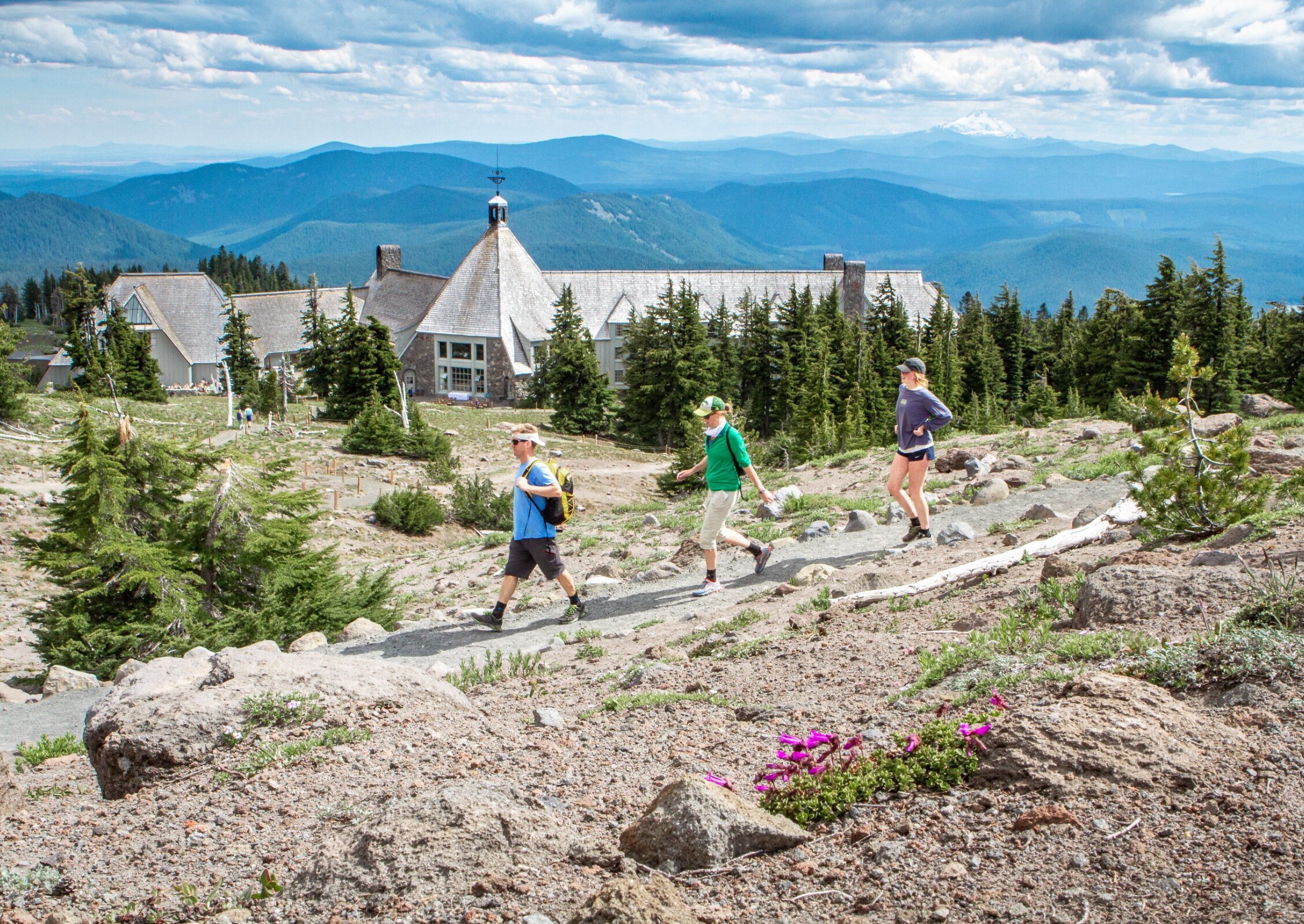Three people hiking Mt. Hood with Timberline Lodge in the background